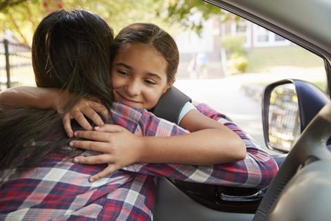 女儿和母亲在车里互相拥抱问候。
