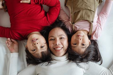 一个女人和两个孩子躺在一起。